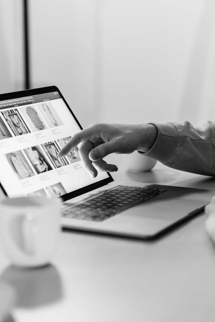 about-img Black and white photo of a person shopping online on a laptop, highlighting e-commerce technology.
